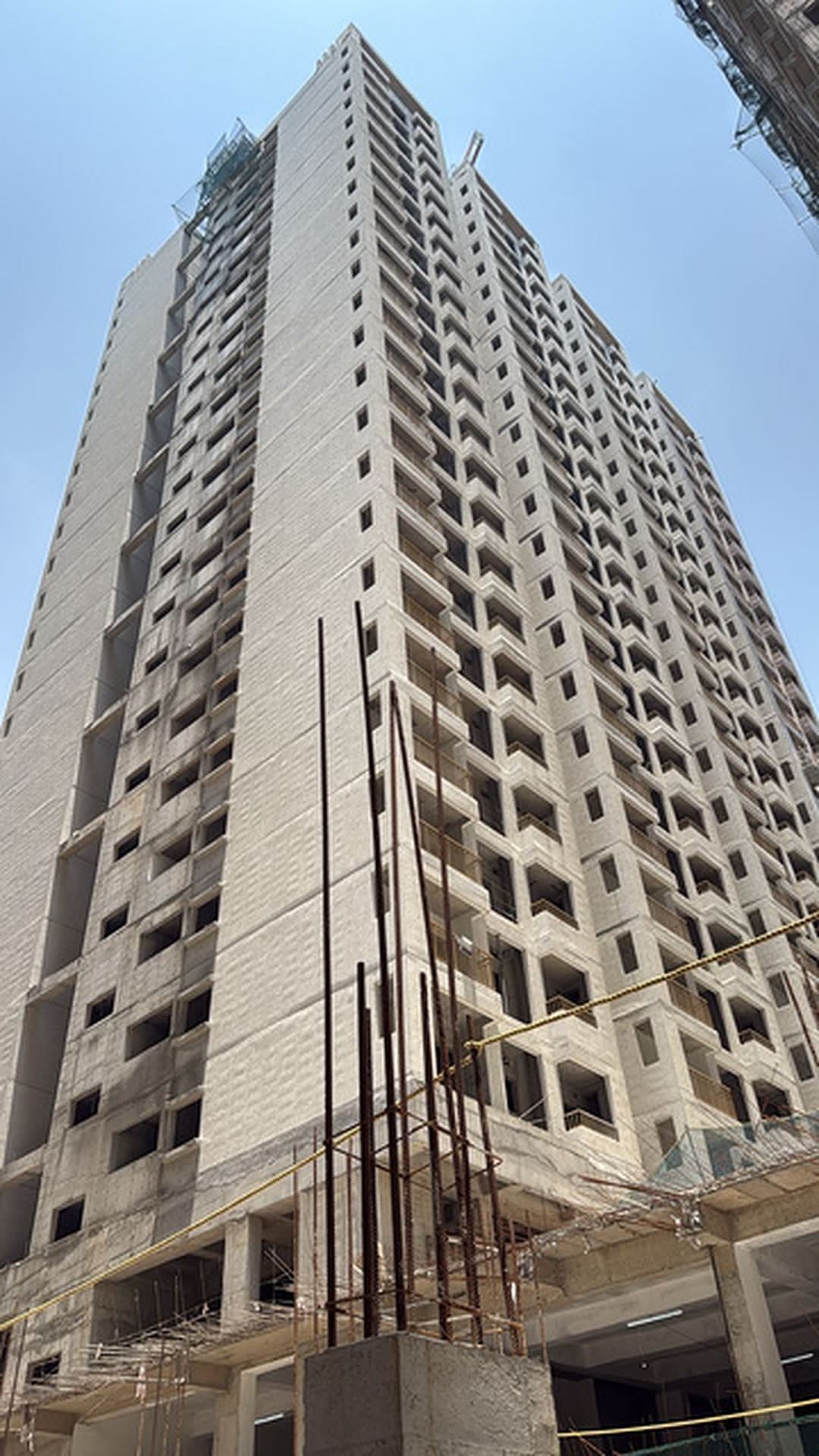 Vasavi Urban Raise residential tower under construction, showing exposed concrete floors and scaffolding